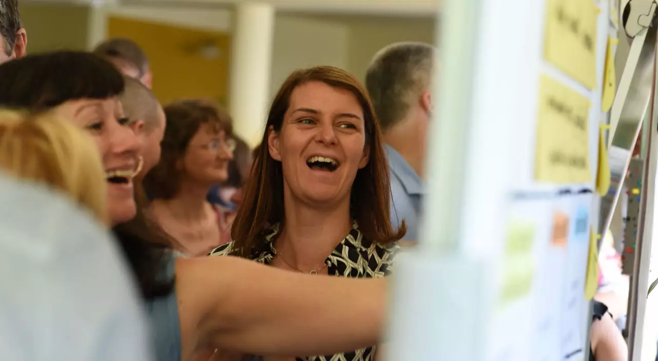 Mehrere Personen vor Flipchart, unterhalten sich zu kreativen Seminar Methoden